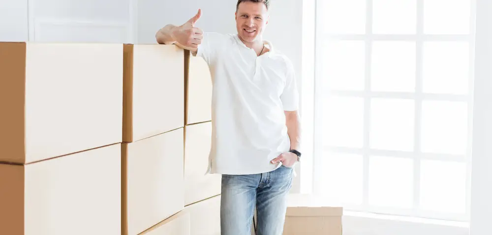 מוביל עומד לייד קופסעות לפני הובלת דירה