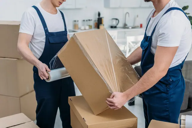 שני מובילים עוטפים ארגז לפני ההובלה
